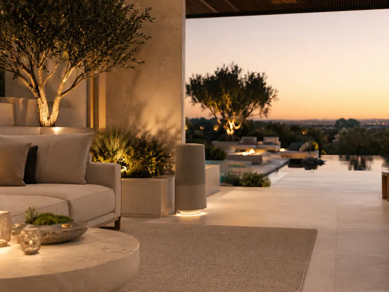 A terrace lounge at sunset, softly lit, looking out over the hills
