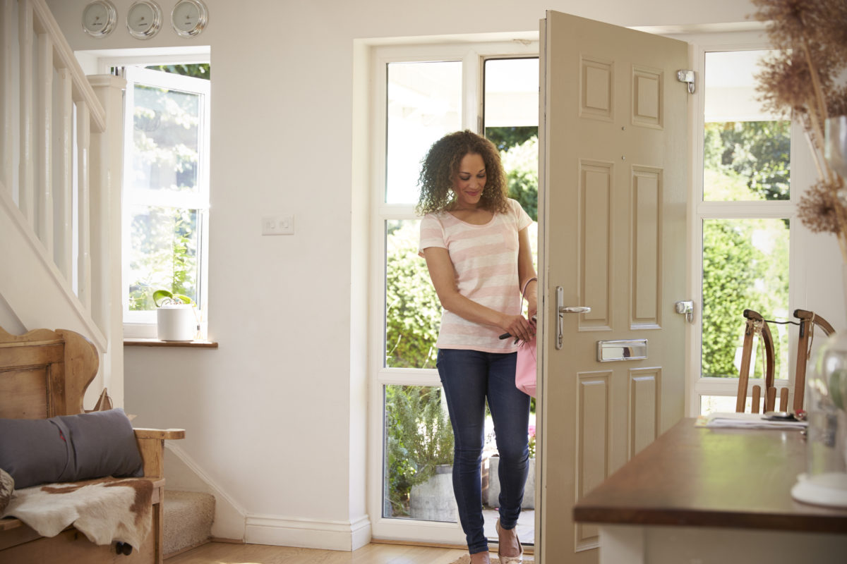 Woman Returning Home And Opening Front Door