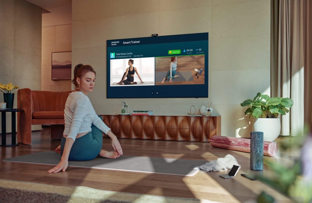 A woman is exercising while watching a fitness video.